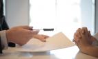 Dos personas con un documento y un bolígrafo