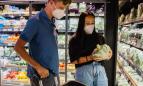Dos jóvenes en la sección de alimentación de un supermercado.