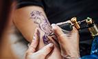 Persona consumidora en un establecimiento de tatuajes